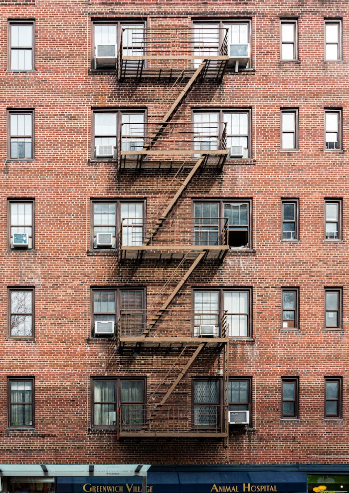 Brick facade with fire escapes in Greenwich Village, NYC.